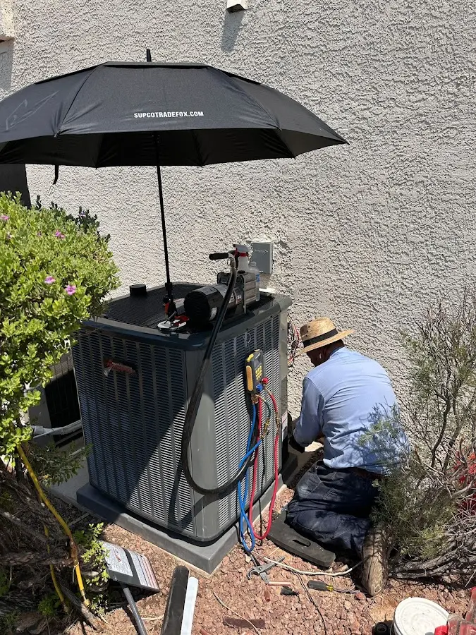 HVAC technician performing outdoor AC maintenance in Plum