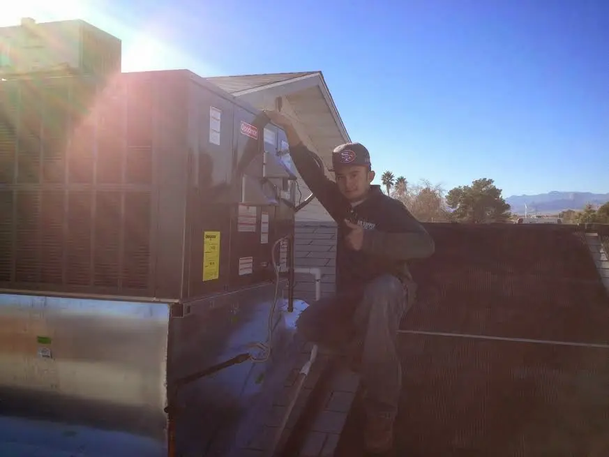HVAC technician performing Air Duct Cleaning on a rooftop unit in Plum